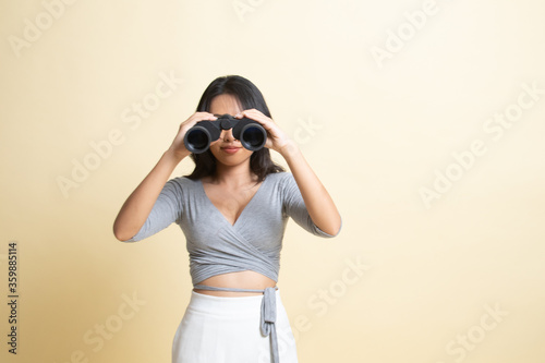 Young Asian woman with binoculars. © halfbottle
