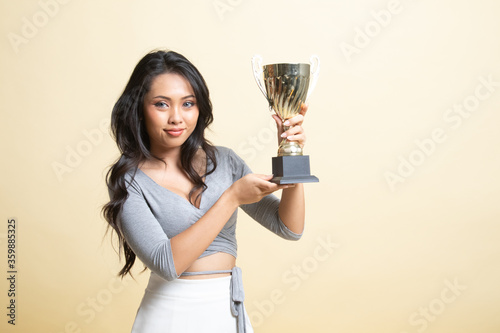 Successful young asian woman holding a trophy.