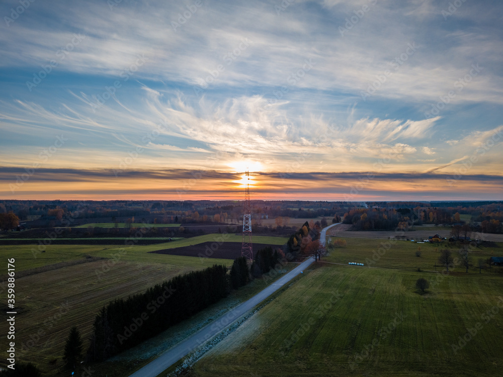 Drone photo of empty road leading through the rural village - colorful autumn sunset