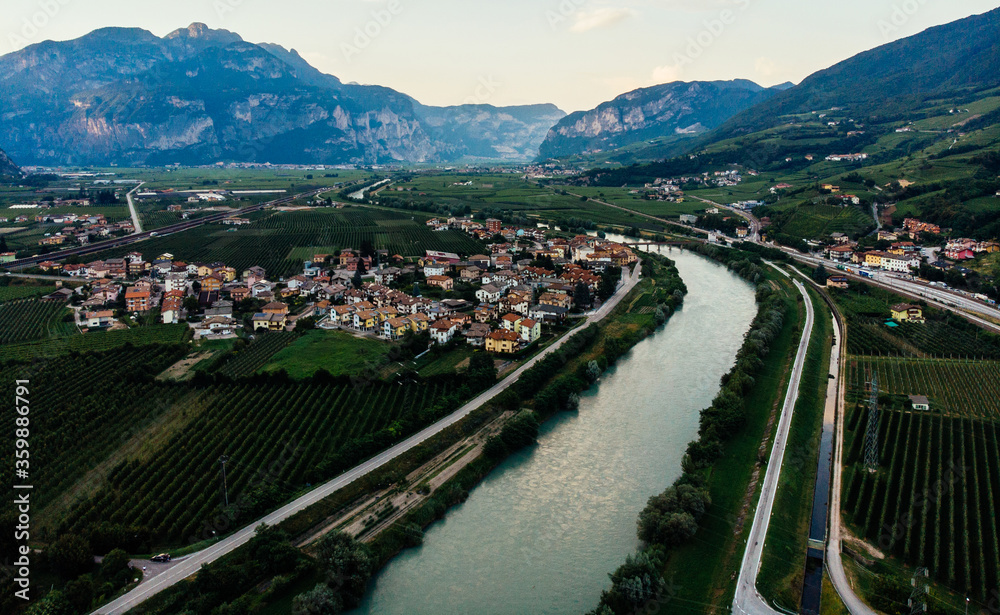 Bird's eye view of ideal area with good climate for growing grapes, valley located in Italian mountain gorge with small town. Beautiful river in countryside, environmentally friendly land