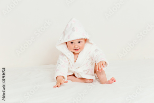 Baby less than a year old in a bathrobe after swimming