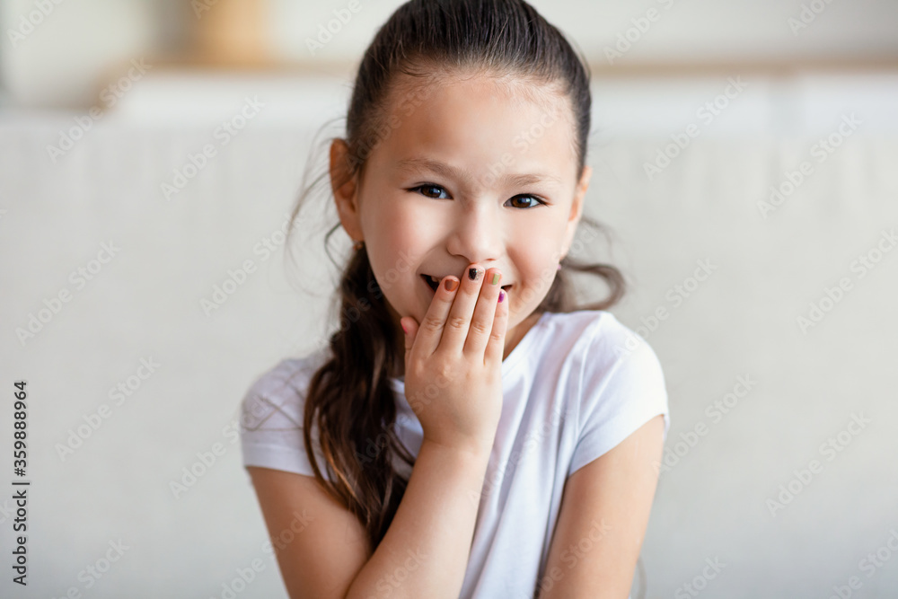 Cute Girl Laughing Covering Mouth Sitting On Couch At Home Cute Girl Laughing Covering Mouth Sitting On Couch At Home