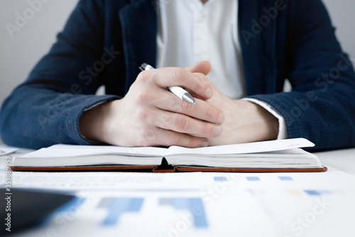 Cropped view of businessman works with financial papers at the table. Finance concept
