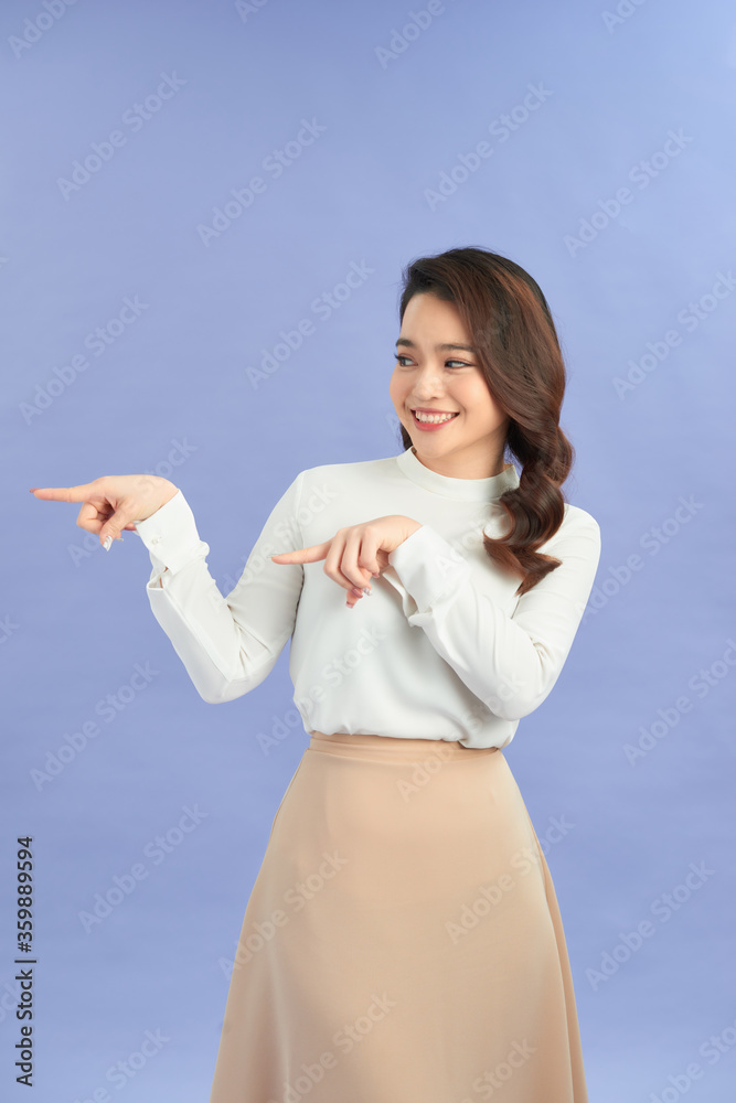 Young elegant woman pointing at purple background Young elegant woman pointing at purple background