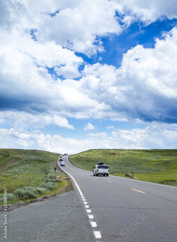 Crooked road with RV in Yellowstone, under cloudy sky 