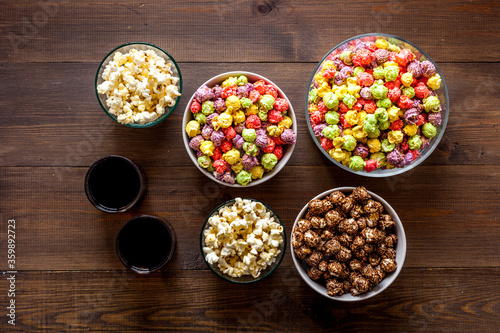 Set of flavored popcorn and soda on wooden table top view