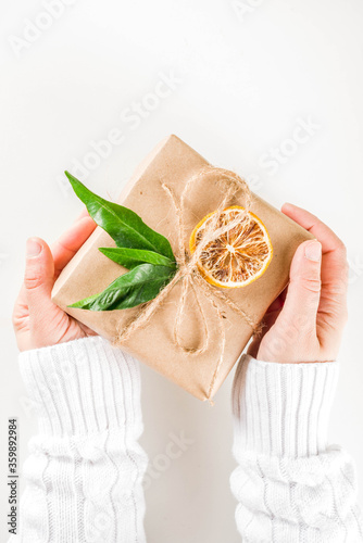Woman hands holds rustic decorated christmas gifts