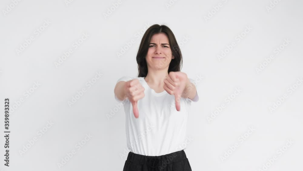 Dislike gesture. Bad idea. Criticizing woman showing thumbs down with disgust isolated on white background. Dislike gesture. Bad idea. Criticizing woman showing thumbs down with disgust isolated on white background.
