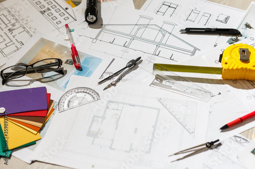 Architect's workspace with rolled house plans and blueprints