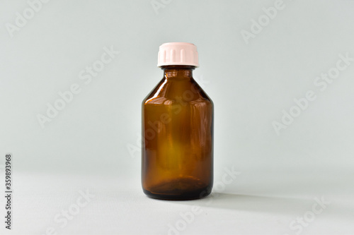 Empty glass brown bottle on a light background