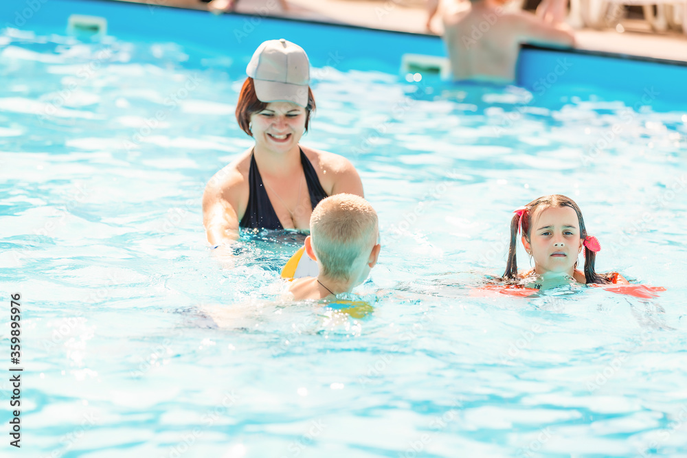 mother and children in the pool