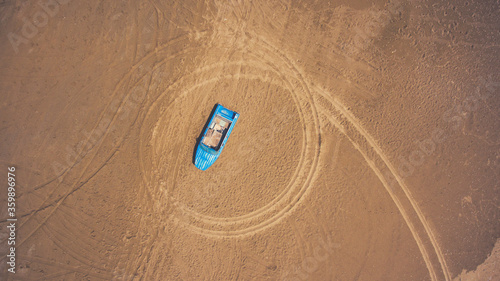 Top view aerial photo from flying drone of a blue boat on a beach in Thailand in sunny summer day. One wherry is lying on a sand with copy space for your travel blog