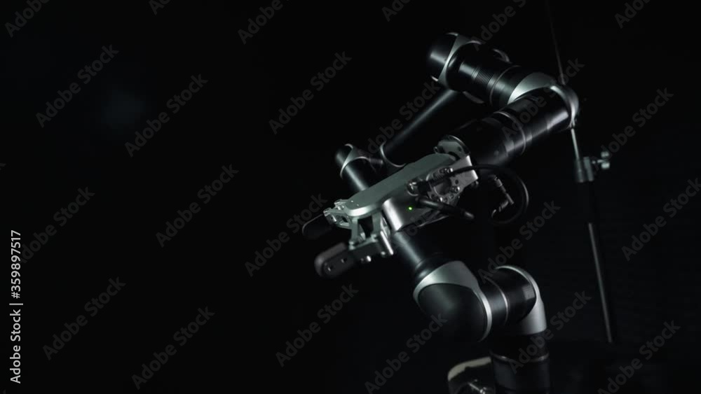 Futuristic robot arm moves randomly in space, system failure, mad robot on black background, dance of the robot manipulator.