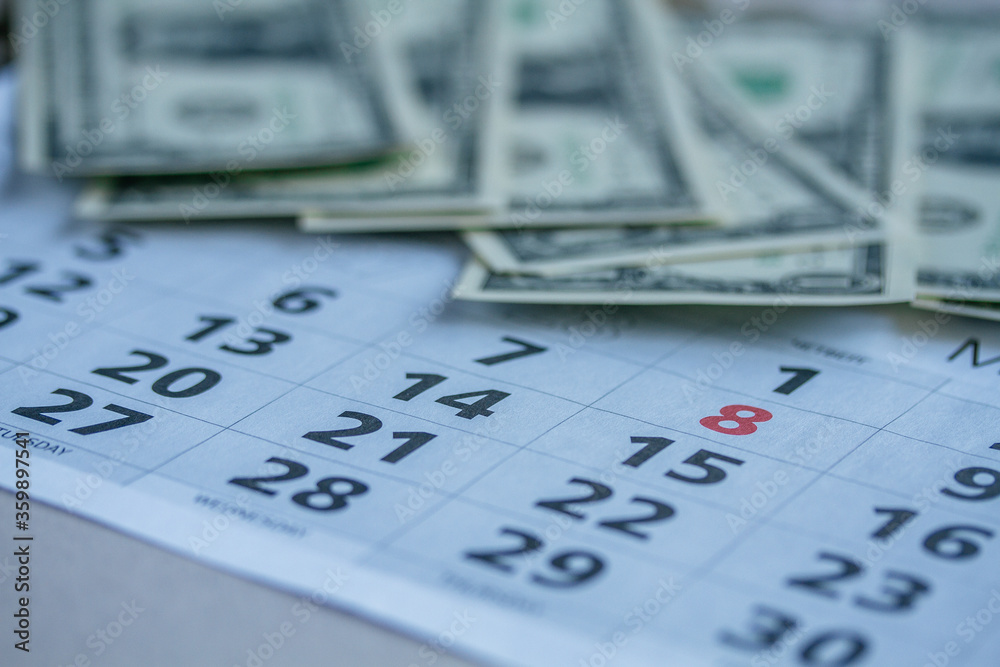Banknotes of dollars on calendar sheets closeup Banknotes of dollars on calendar sheets closeup