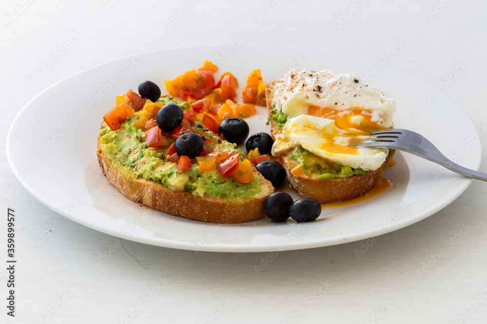 Tasty sandwich with poached egg, avocado and tomatoes Tasty sandwich with poached egg, avocado and tomatoes