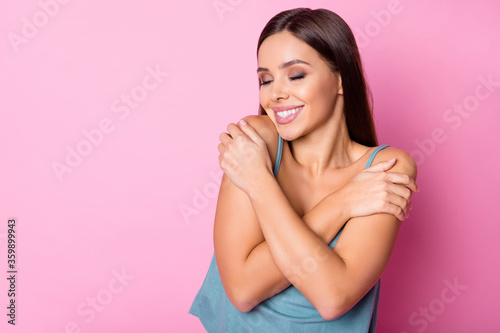 Portrait of positive content girl hug herself enjoy her fresh skin after spring weekend walk wear good look copyspace singlet isolated over pastel color background