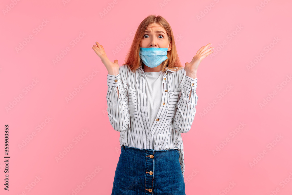 shocked, surprised young woman in a medical protective mask, on a pink background. Coronavirus shocked, surprised young woman in a medical protective mask, on a pink background. Coronavirus