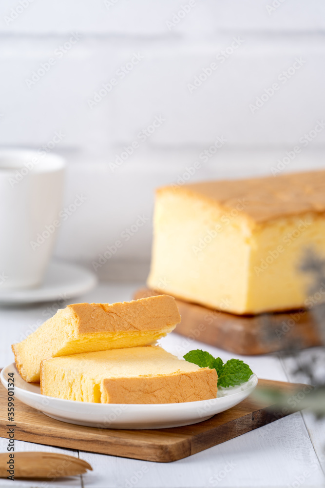 Plain classic Taiwanese traditional sponge cake (Taiwanese castella kasutera) on a wooden tray background table with ingredients, close up. Plain classic Taiwanese traditional sponge cake (Taiwanese castella kasutera) on a wooden tray background table with ingredients, close up.