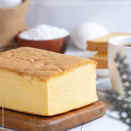 Plain classic Taiwanese traditional sponge cake (Taiwanese castella kasutera) on a wooden tray background table with ingredients, close up.