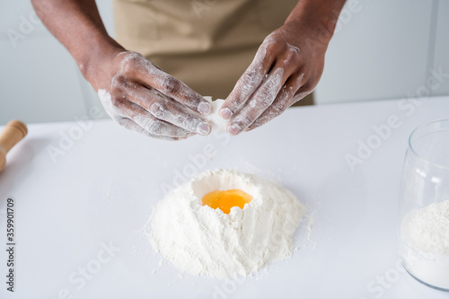 Cropped close-up view of his he nice hands guy professional confectioner making fresh bread egg boat pie hachapuri national culinary cookery confectionery in modern light white interior house kitchen photo