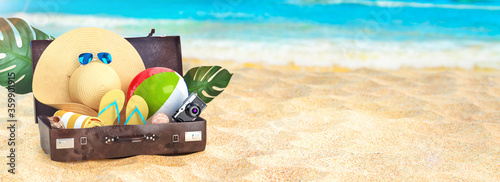 Summer vacation concept. Beach and the sea, sunny day summer banner. Flip flops, sun glasses, shells, camera, beach ball, luggage. 