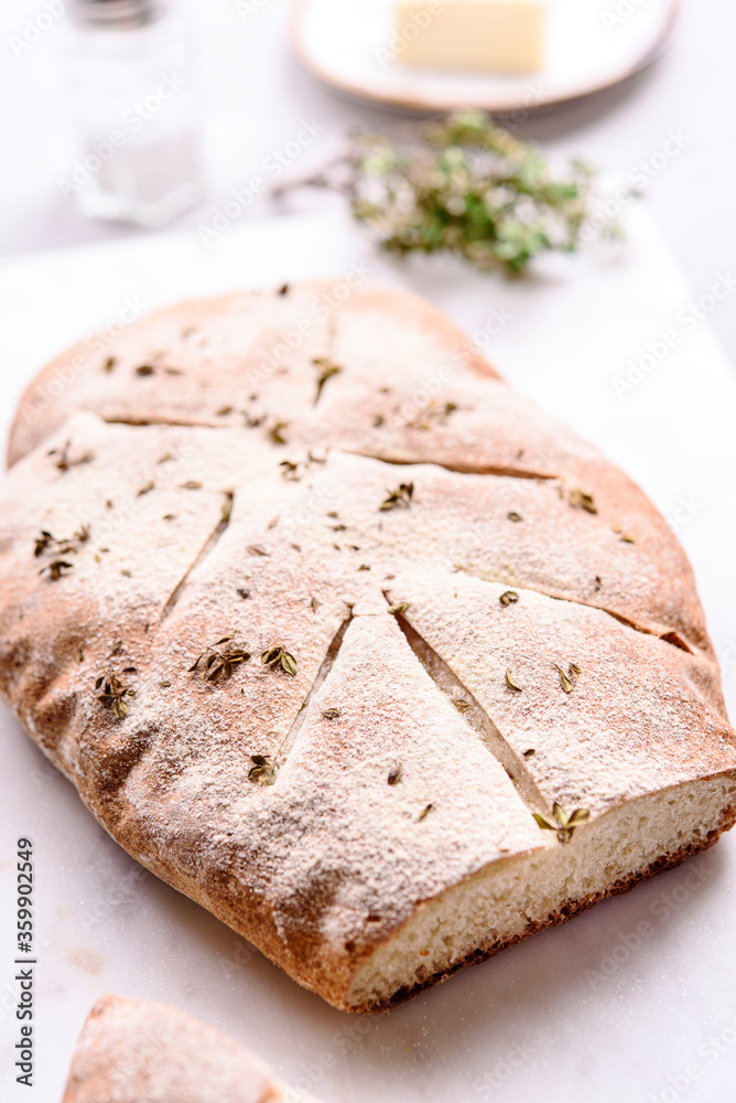 Homemade fresh baked Fougasse (French Bread) with thyme and olive oil on white background. Traditional Provencal dishes. Selective focus Homemade fresh baked Fougasse (French Bread) with thyme and olive oil on white background. Traditional Provencal dishes. Selective focus