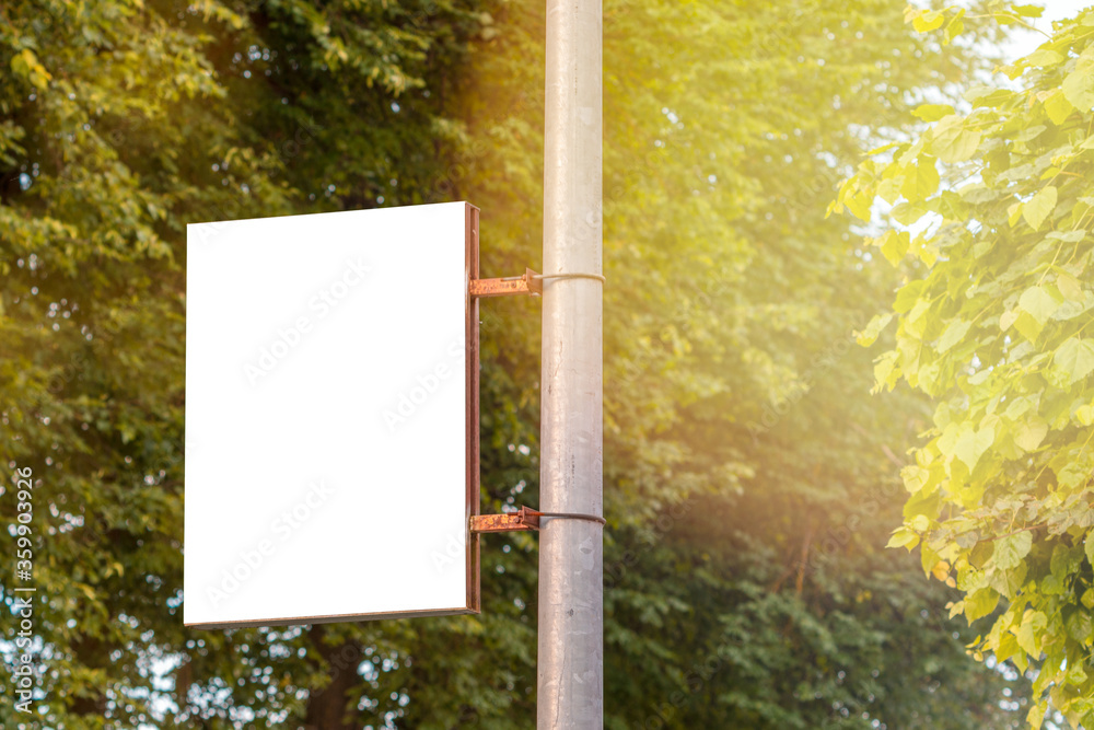 The blank advertising banner suspended on the street lamp pole - obrazy, fototapety, plakaty 