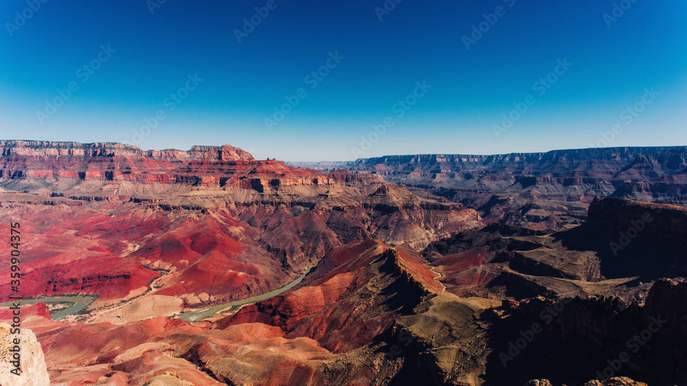 Bird's eye view of high red stone rocks without vegetation in famous Grand Canyon National Park, aerial view of deep abyss surrounded with mountains in Arizona state
