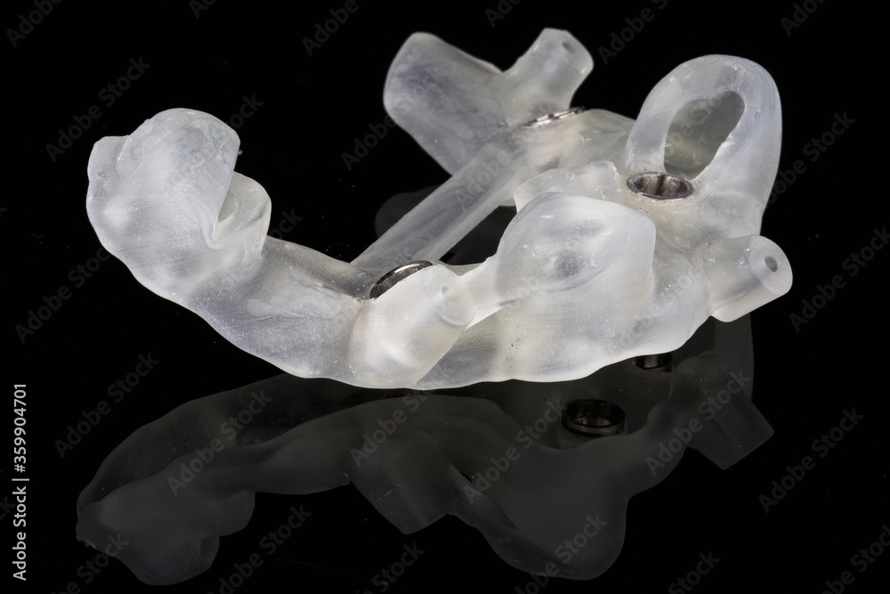 Fototapeta premium dental template resting on the patient’s teeth for implantation, shot on a black background side view