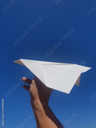 hand holding paper airplane