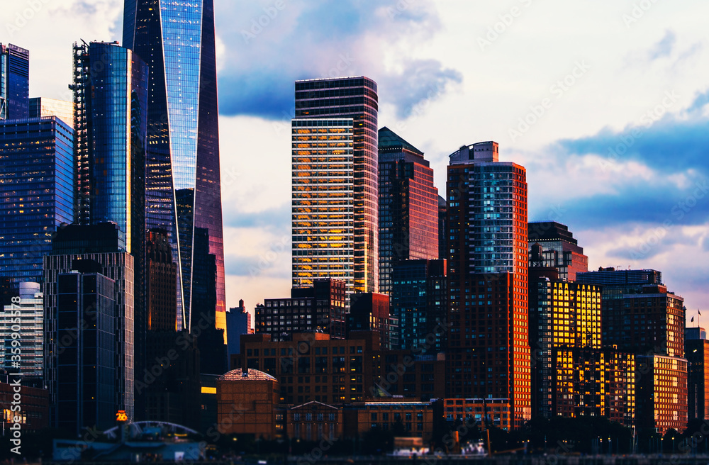 Obraz premium Panoramic view of Manhattan Island with sunset reflection in glass buildings.Scenery skyline view of contemporary skyscrapers of downtown financial district in New York. Gold sunset over NYC cityscape