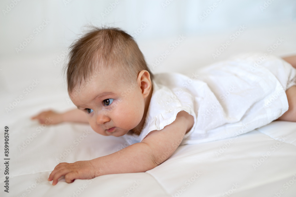 Caucasian baby girl as he lays on a fluffy down duvet comforter on a bed Caucasian baby girl as he lays on a fluffy down duvet comforter on a bed