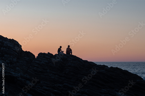 Disfrutando del atardecer en las rocas de la playa. Costa cantábrica. País Vasco. 