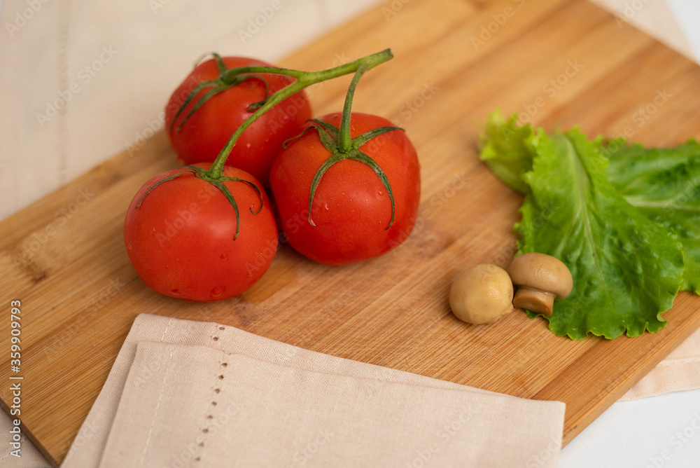 Mushrooms with lettuce and tomatoes on a wooden board. Mushrooms with lettuce and tomatoes on a wooden board.