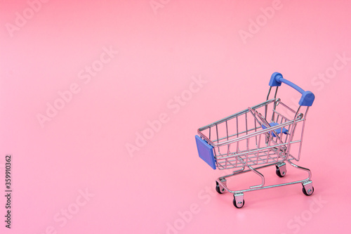 Shopping concept : Blue shopping cart on pink background. online shopping consumers can shop from home and delivery service. with copy space.