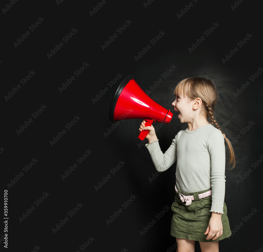 Cute little girl speaking through a megaphone against a blackboard. Kid with loudspeaker Cute little girl speaking through a megaphone against a blackboard. Kid with loudspeaker