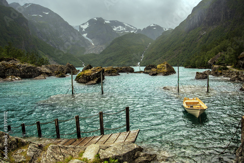 Lonely boat on the lake in the harsh mountains