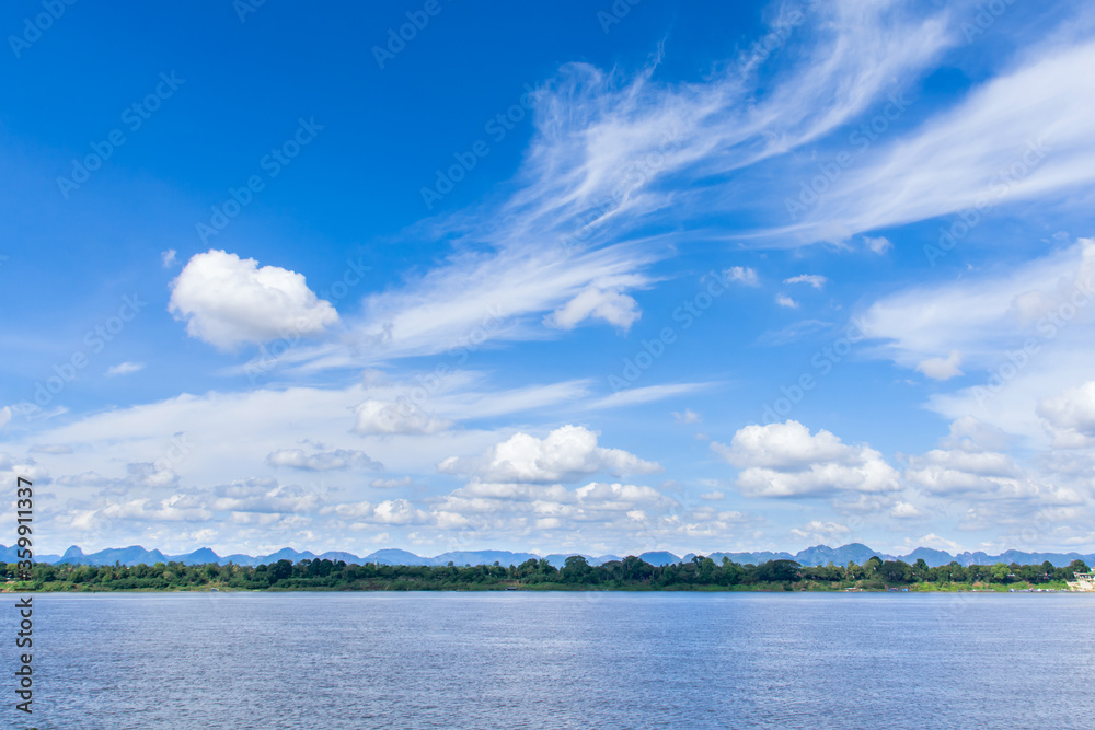 River and cirrus, cumulus clouds on blue sky background.