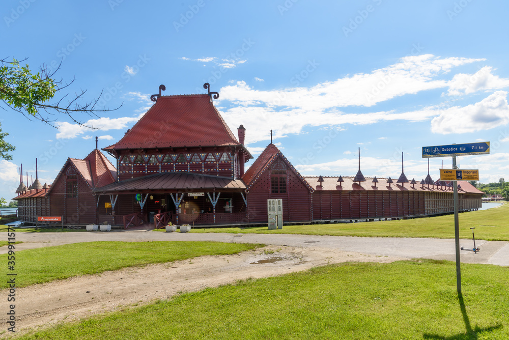 Subotica, Serbia - June 19, 2020: View of the female bath-house at Palic Lake, built from wood in 1912 after plans of architects Komor and Jakab in style of Hungarian secession. Subotica, Serbia - June 19, 2020: View of the female bath-house at Palic Lake, built from wood in 1912 after plans of architects Komor and Jakab in style of Hungarian secession.