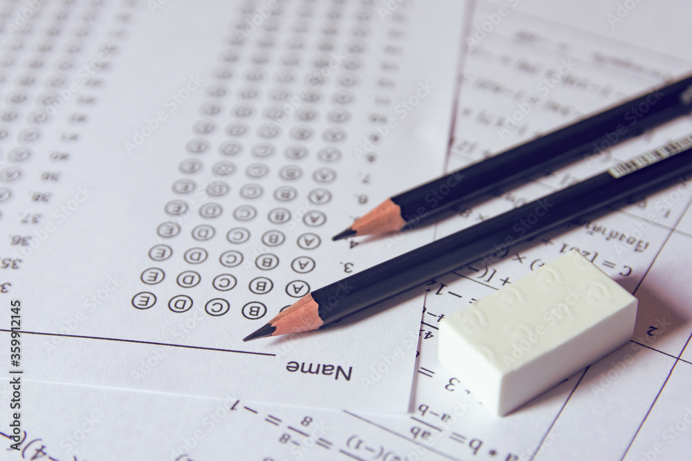 Pencil and eraser on answer sheets or Standardized test form with answers bubbled. multiple choice answer sheet Pencil and eraser on answer sheets or Standardized test form with answers bubbled. multiple choice answer sheet