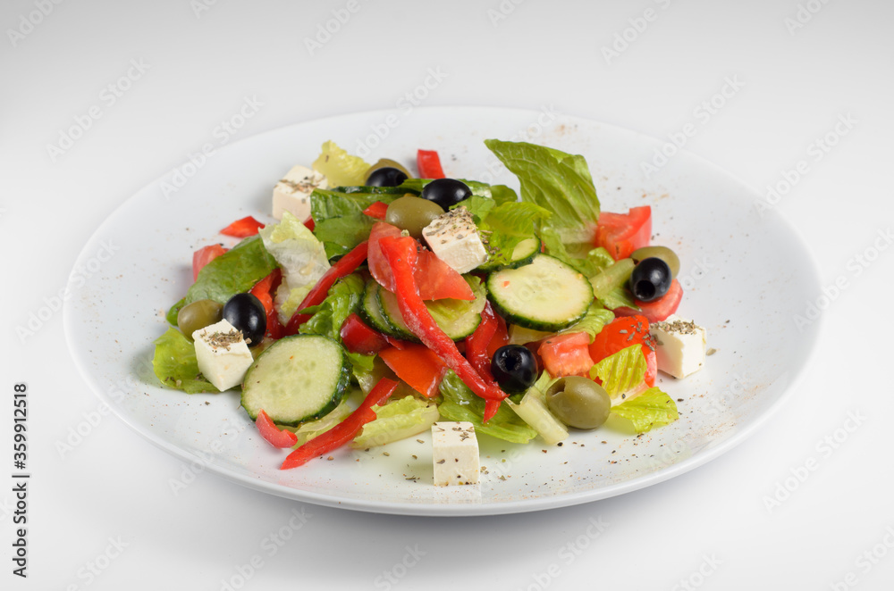Neapolitan mix - vegetarian tasty and healthy salad of Italian cuisine with bell pepper, salad mix, olive oil, tomato, olives, cucumber, olives, feta cheese and Balsamico sauce.