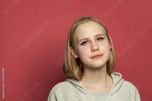 Portrait of pretty girl with makeup on bright pink background