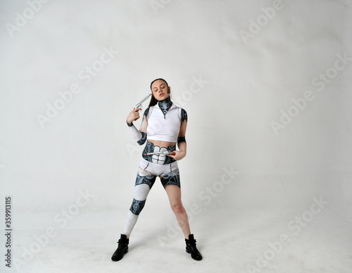 beautiful girl in robot clothes posing with silver revolvers