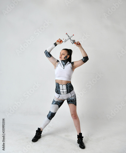 beautiful girl in robot clothes posing with silver revolvers