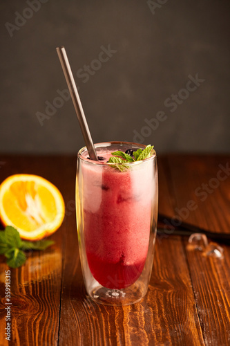 Tasty blackberry smoothie with mint and fresh berries in glasses on wooden background