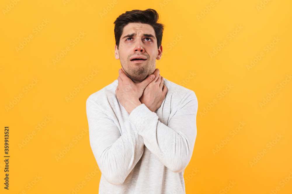 Photo of sick unhappy man having painful sore throat and touching neck Photo of sick unhappy man having painful sore throat and touching neck