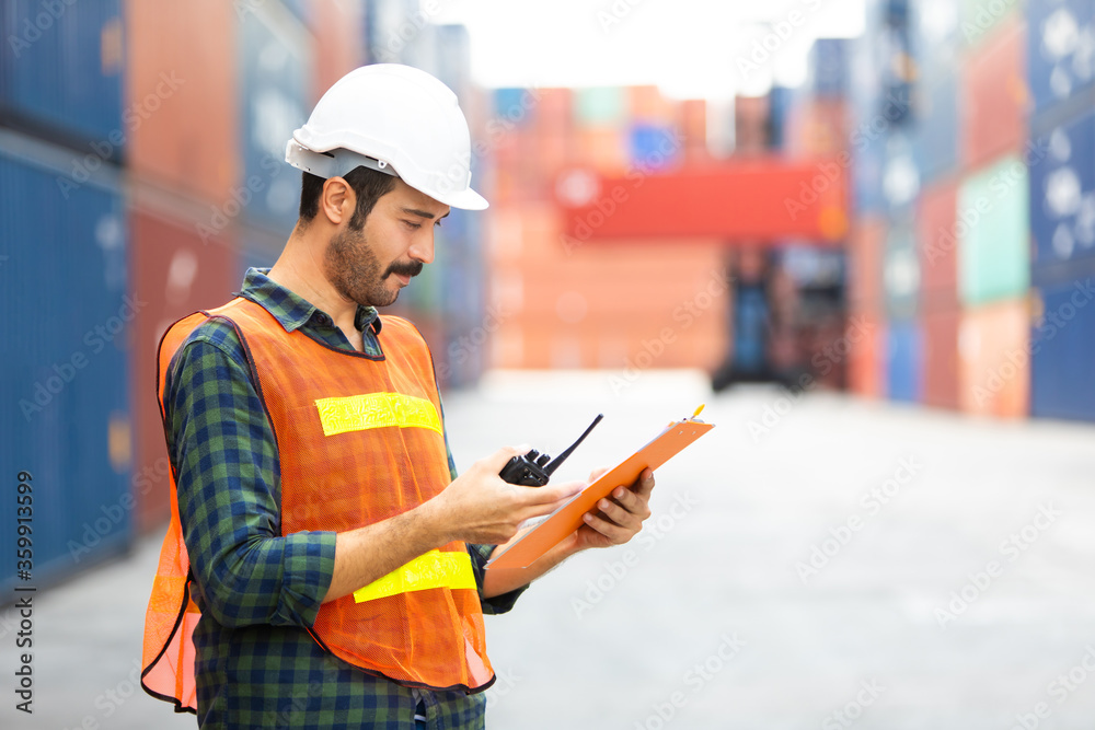 foreman maneger working through a radio communication with the workers in the container yard at port of import and export goods. foreman maneger working through a radio communication with the workers in the container yard at port of import and export goods.