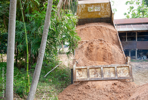 The truck is loading the soil to fill the ground.
