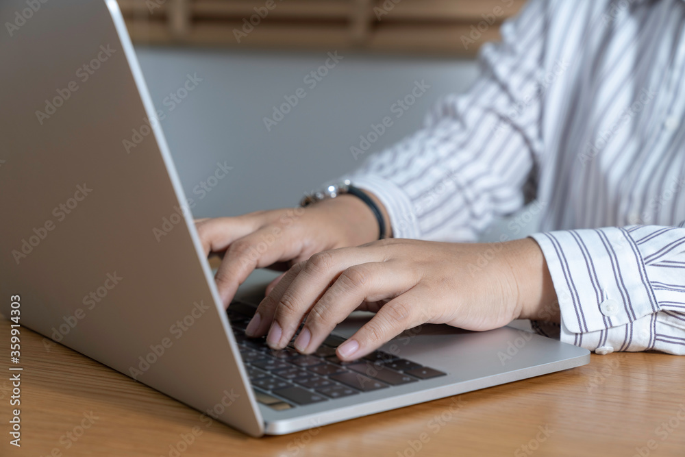 Manager working on a project in open space office. Laptop on wood. Manager working on a project in open space office. Laptop on wood.
