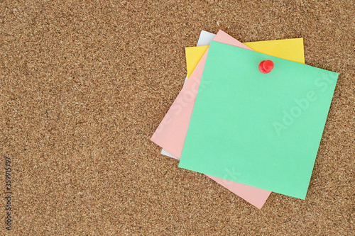 collection of colorful variety post it. paper note reminder sticky notes pin on cork bulletin board. empty space for text.